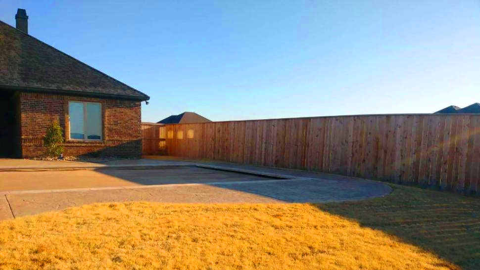 a house backyard with a newly built cedar fence